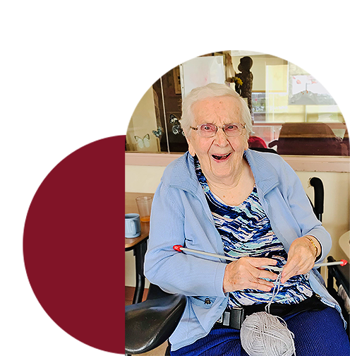 Happy senior lady with knitting needles and a ball of yarn